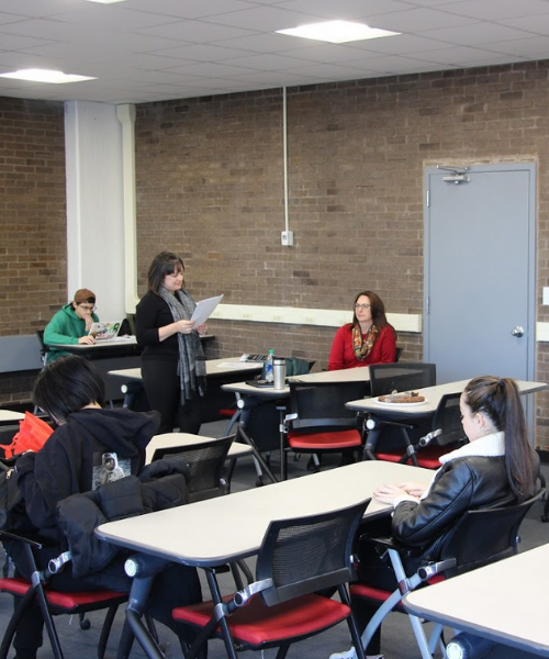 Woman reading literary karaoke to students