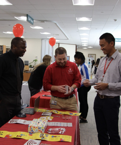 Attendees in conversation at a representative's table