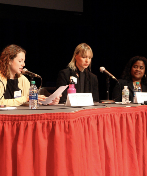 Women on panel speaking at Open Access Symposium
